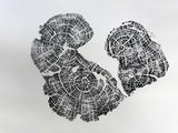 Black ink print of two old growth juniper tree rings showing detailed growth patterns and cracks on a white background.