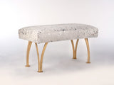 Rectangular bench with speckled hair-on-hide upholstery and four curved brass split legs, shown against a light background.