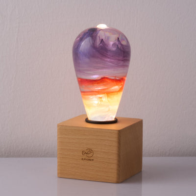 Passion Light Bulb decorative resin LED lamp with artistic glow, shown with wooden base options