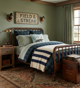 Rustic bedroom with a dark wood spindle bed dressed in blue-green plaid bedding, a bear-print pillow, striped cream and navy throw, and two duck head wall mounts.