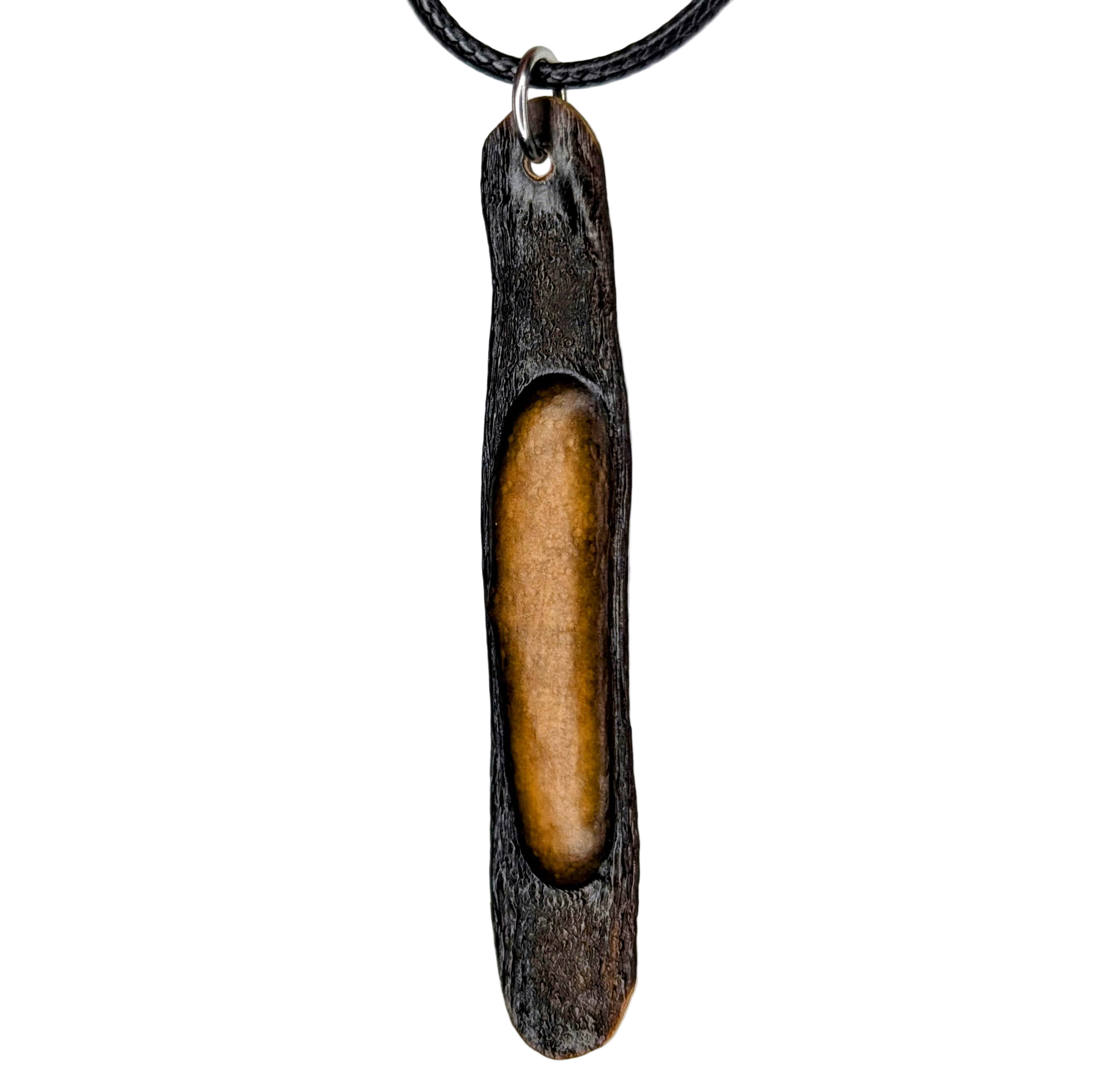 Halimaris pendant necklace with dark textured exterior and warm golden core on black cord