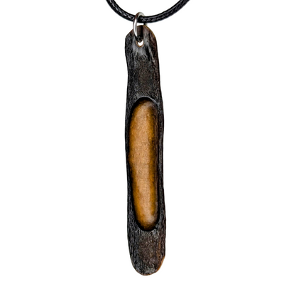 Halimaris pendant necklace with dark textured exterior and warm golden core on black cord