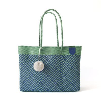 Palmera Woven Super Tote in a neutral palette showcasing woven structure and pompom