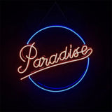 Neon sign with cursive 'Paradise' in warm pinkish-orange, framed by an incomplete blue circle against a black background.