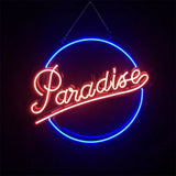 Paradise Neon Signs Light glowing with pink and orange colors, hanging against a white background.