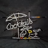 White neon sign spelling 'Cocktails' with a white umbrella above, yellow and red accents, and outlines of cocktail glasses on a black background.