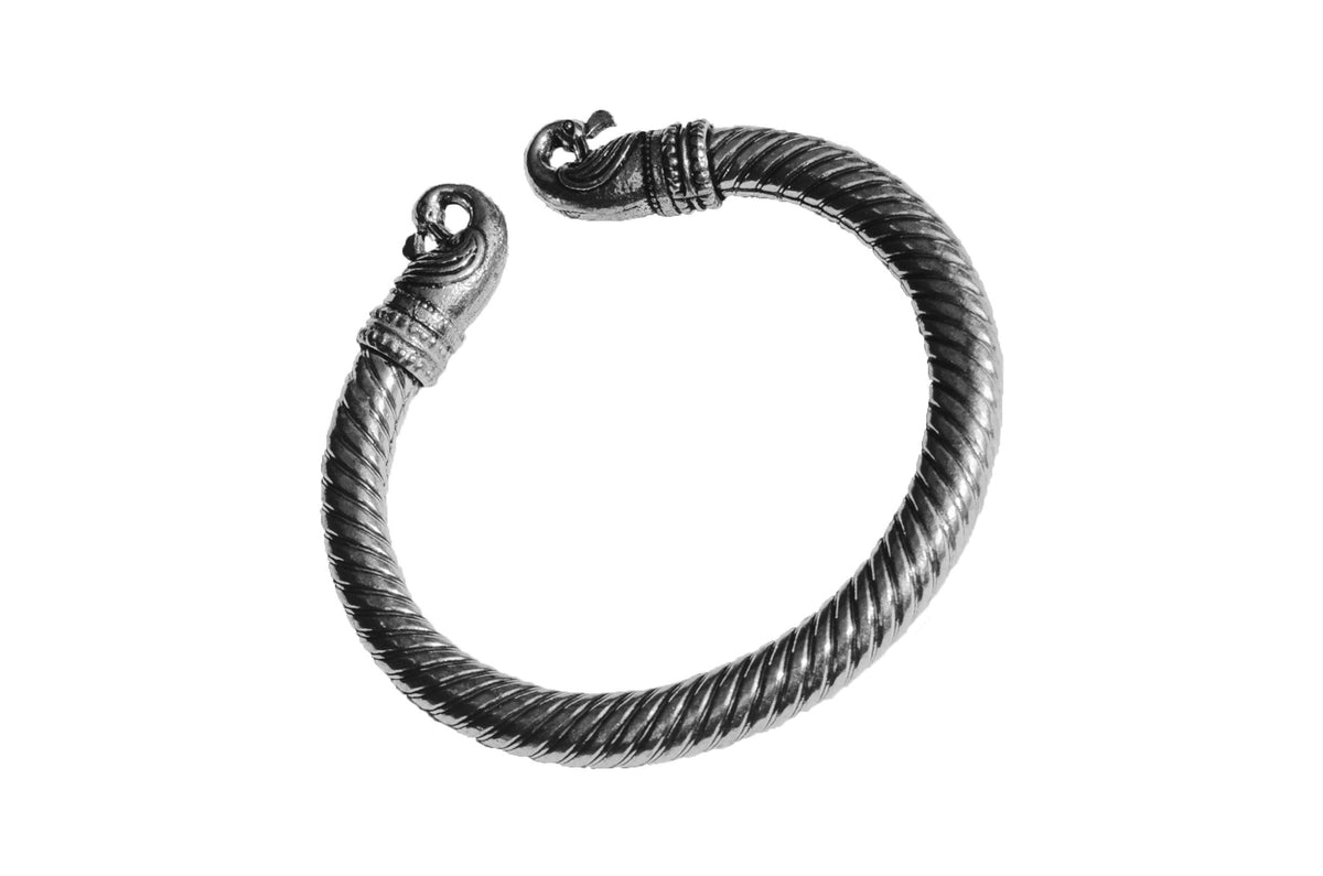 Antique Norse Viking bracelet with twisted design and peacock head terminals, shown in silver-tone metal against white background.