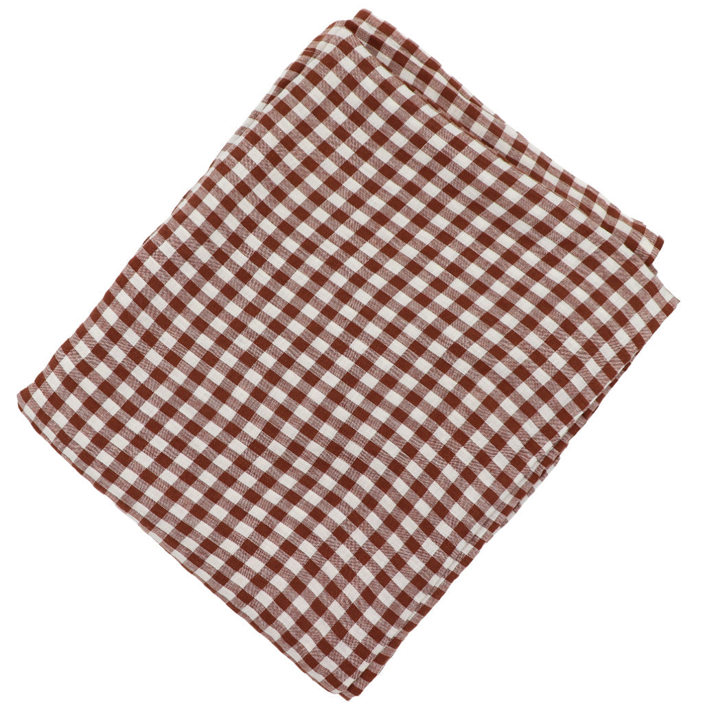 Pecan Plaid Tablecloth with warm brown gingham pattern laid over a dining table with chairs