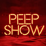 Bright red neon sign spelling "PEEP SHOW" in uppercase letters against a dark background, with glowing bent tubing and visible wiring beneath.