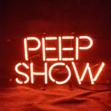 Peep Show Neon Signs mounted on a wall, glowing brightly against a dark background