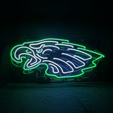 Neon sign of a stylized bird head outlined in bright green with white and blue neon accents on a black background.