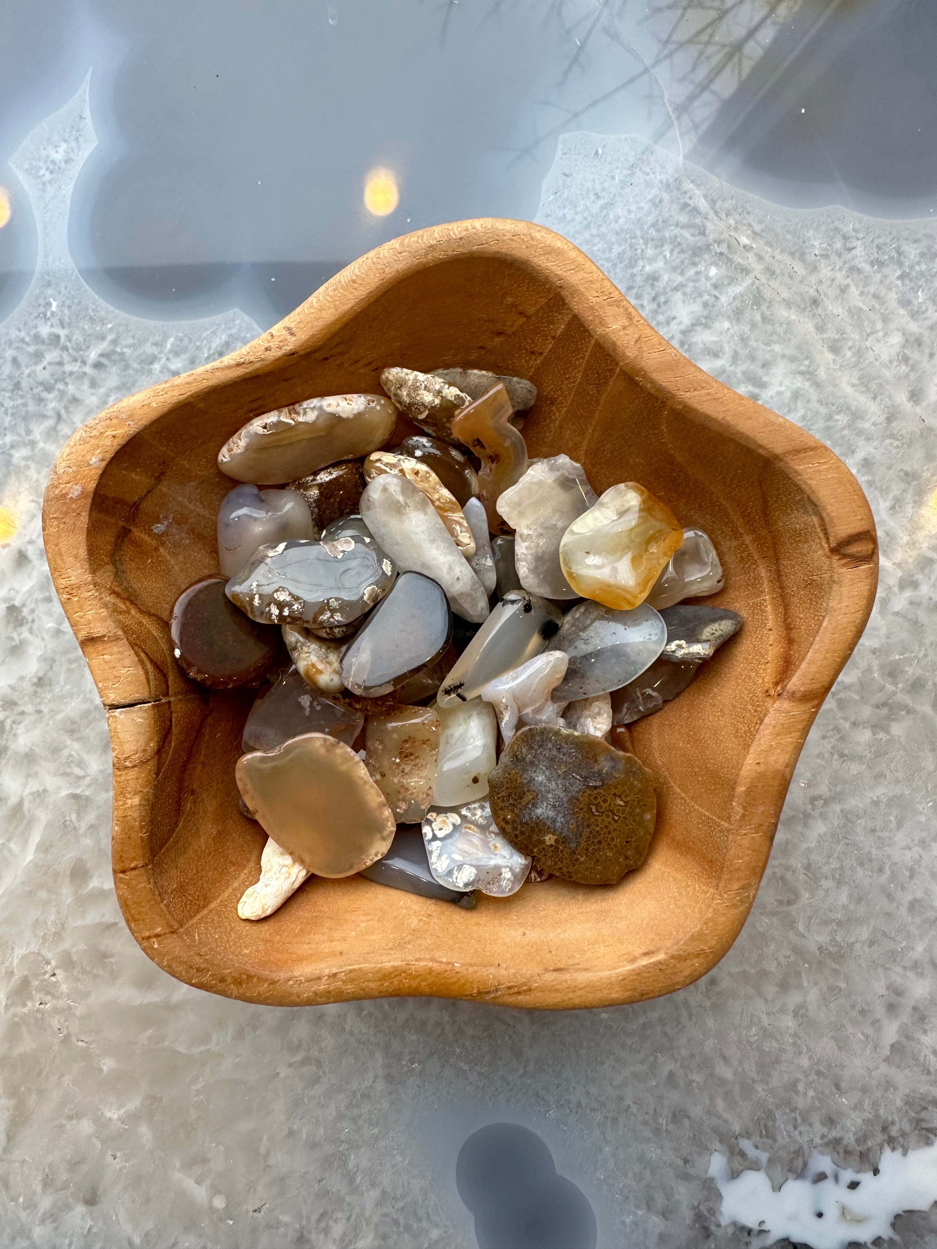 Polished agate stones of various colors and banding on a white surface
