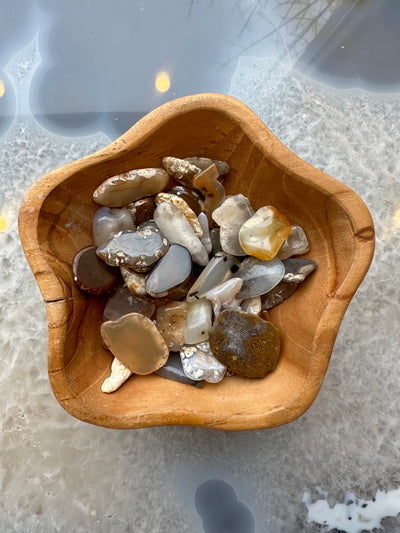 Polished agate stones of various colors and banding on a white surface