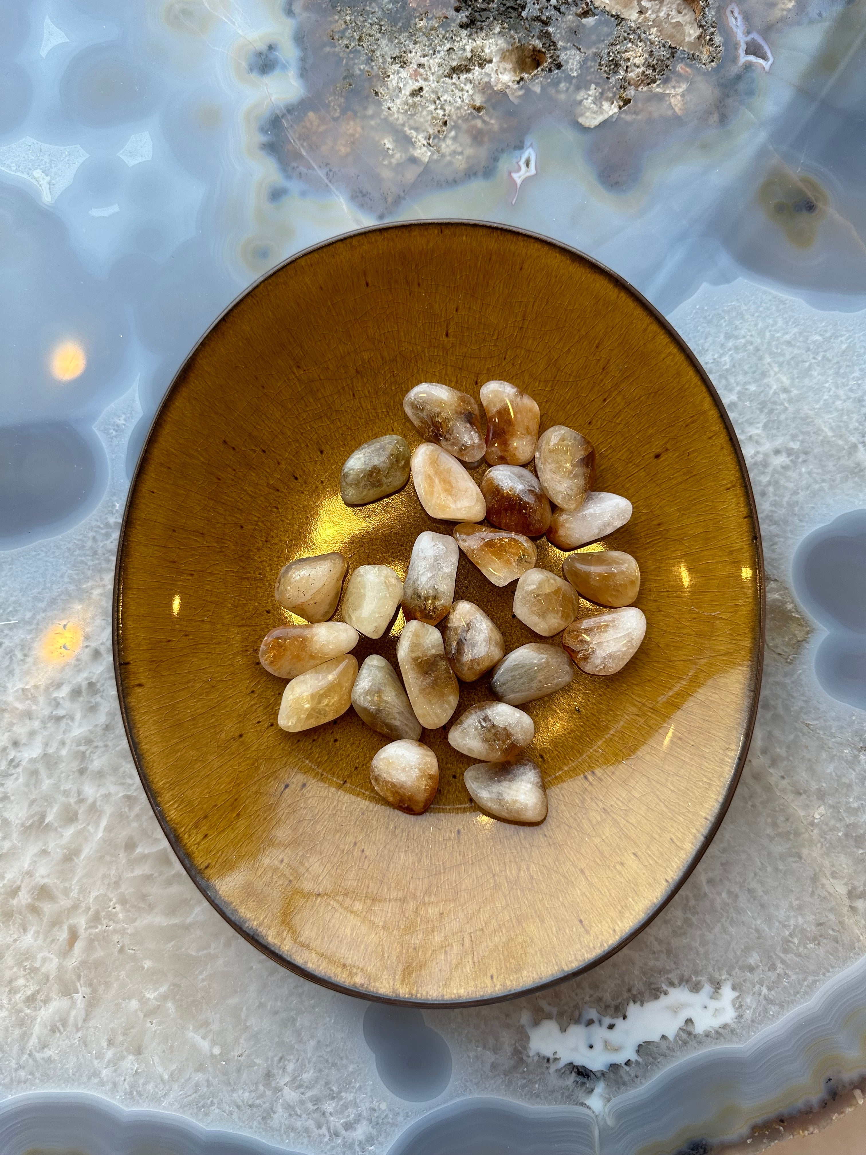 Small tumbled citrine stones in warm yellow hues with smooth rounded edges