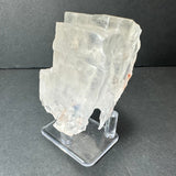 Colorless cubic fluorite crystal from Hardin County, Illinois, shown translucent with irregular edges on a clear acrylic stand against a dark background