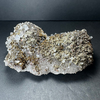 Marcasite crystals on colorless Calcite mineral from Morocco displayed on a dark background