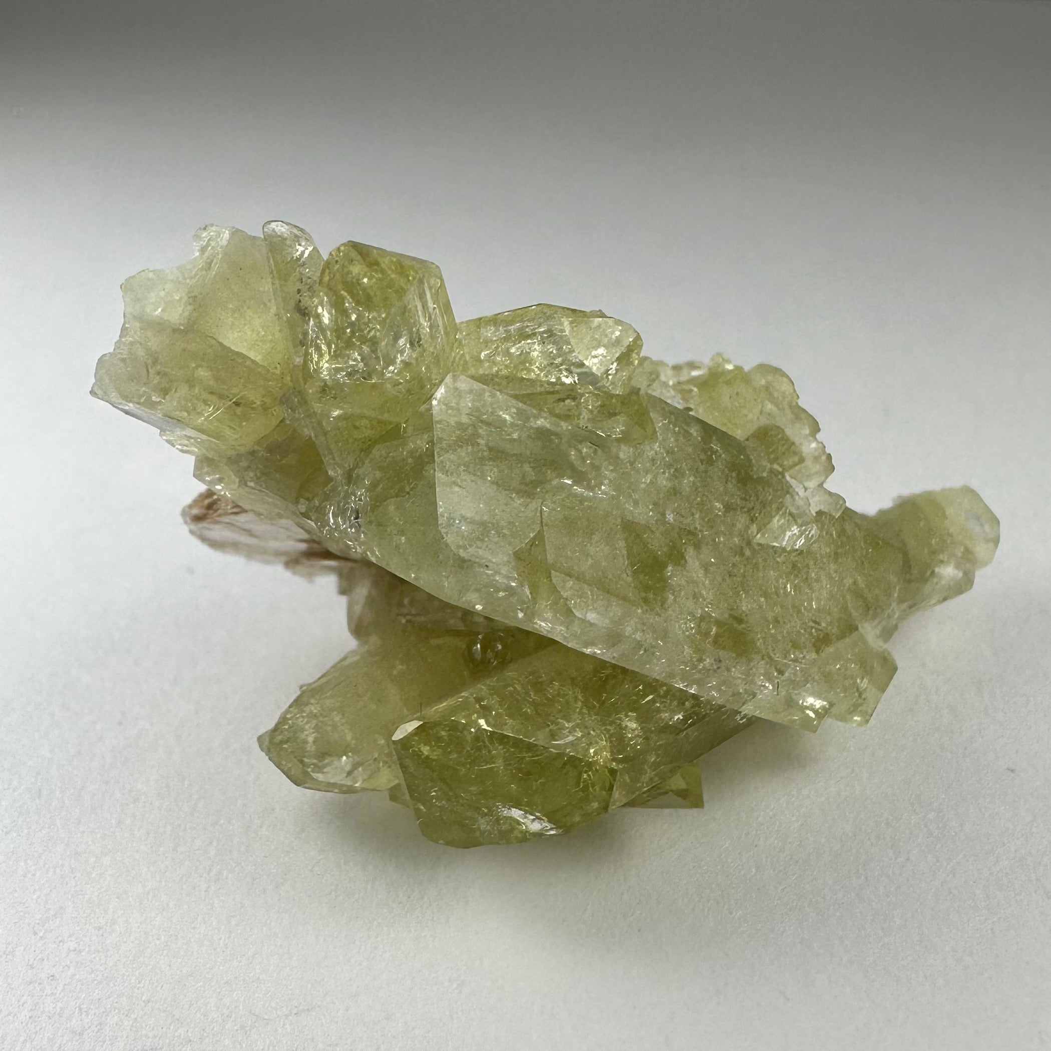Close-up image of the Brazilianite Cluster showing yellow-green crystal formations alongside white Muscovite and Albite from Minas Gerais, Brazil.