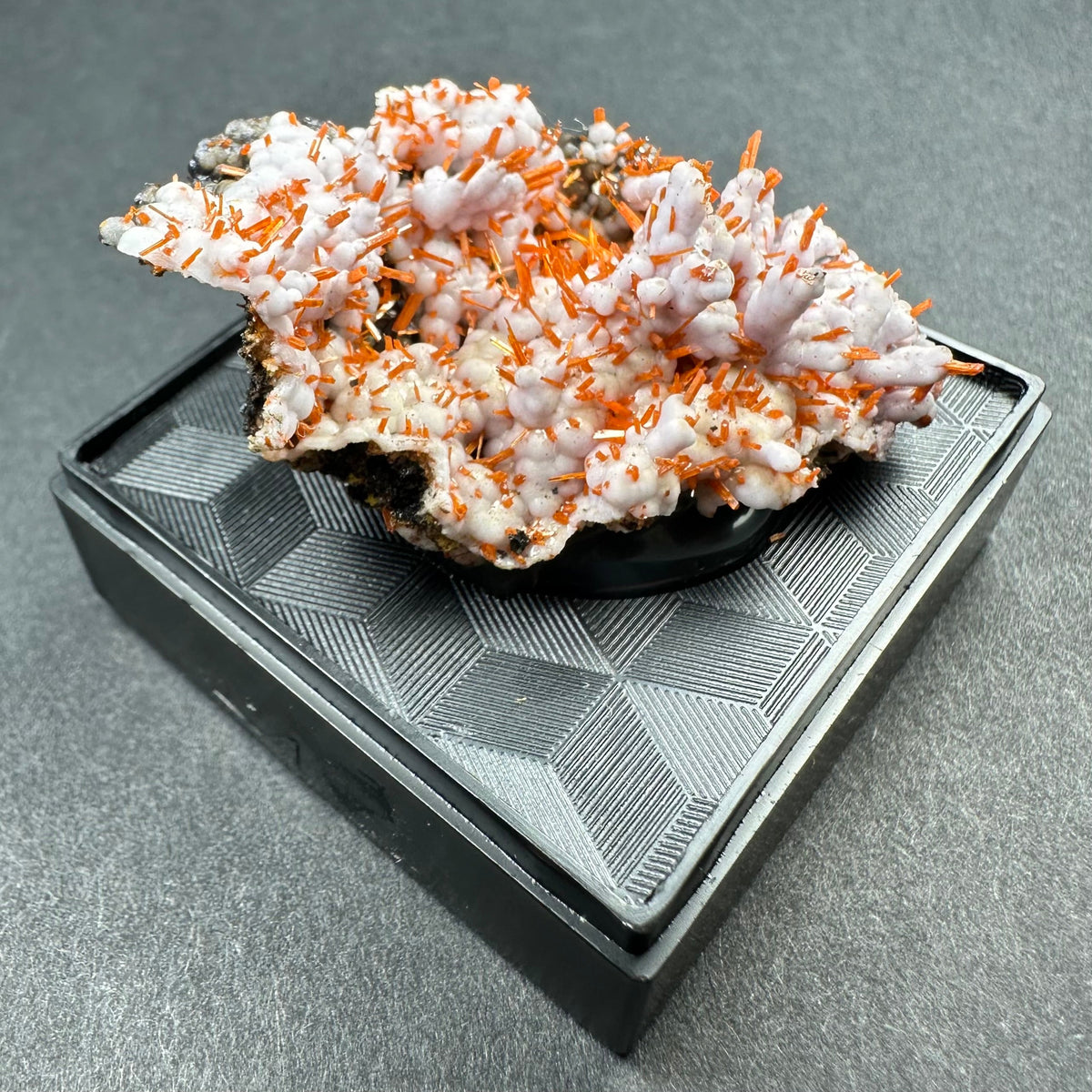 Crocoite on Matrix specimen in clear acrylic display case showing bright orange crystals on a dark rock base