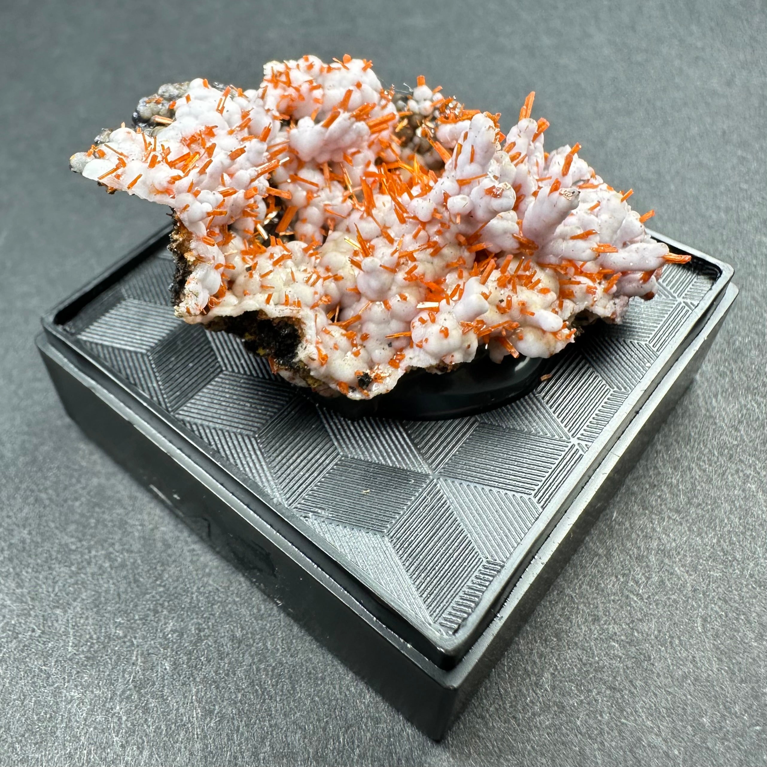 Crocoite on Matrix specimen in clear acrylic display case showing bright orange crystals on a dark rock base
