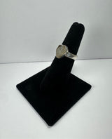 Silver ring with a polished quartz stone set in a hexagonal bezel, displayed on a black velvet ring holder against a plain white background.