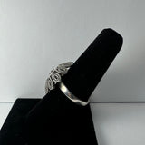 Sterling silver ring with an ornate floral design displayed on a black velvet ring holder against a plain white background.