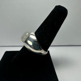 Silver ring with a rounded moonstone cabochon on top, displayed on a black velvet ring holder against a plain light background.