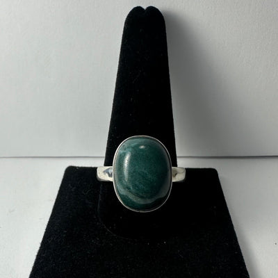 Green Serpentine ring with .925 Sterling Silver band, displayed on a rock