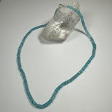 Natural Blue Apatite Necklace displayed on a dark blue fabric background and worn close-up, highlighting the vivid blue stone and sterling silver clasp.