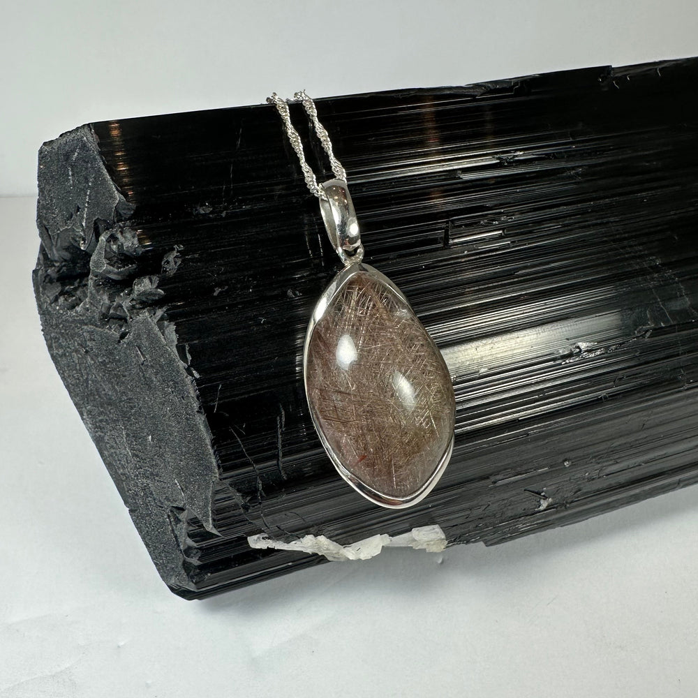 Silver Rutile Teardrop Pendant showing freeform quartz cabochon with needle-like inclusions set in sterling silver clasp
