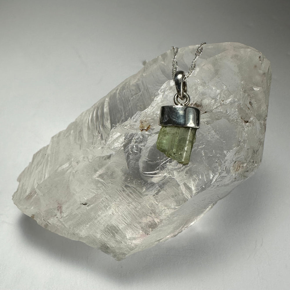 Tourmaline Pendant on a white background, showing greenish-blue tourmaline stone with silver clasp