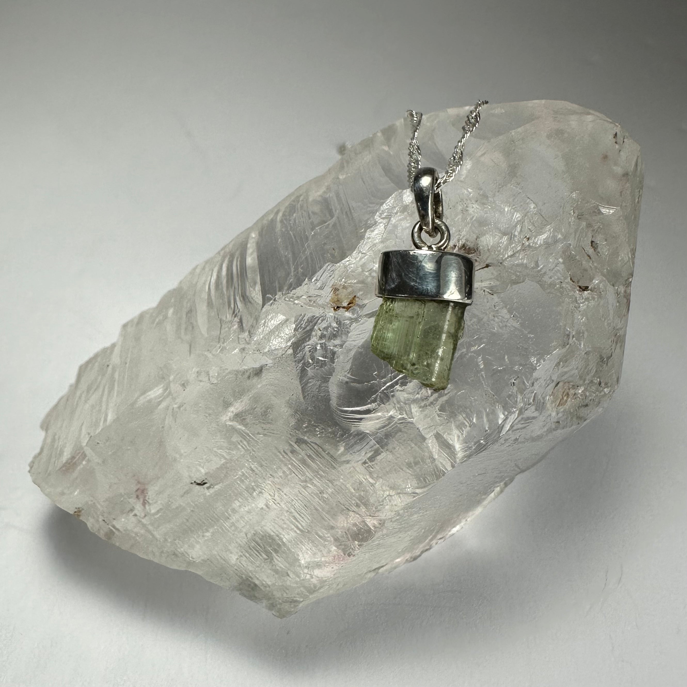 Tourmaline Pendant on a white background, showing greenish-blue tourmaline stone with silver clasp