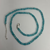 Delicate necklace composed of small translucent blue apatite beads with a silver lobster claw clasp and adjustable chain on a white background.