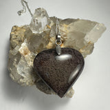 Clear heart-shaped quartz pendant with dark lodalite inclusions set in silver