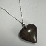 Polished dark brown heart-shaped quartz pendant with subtle lodolite inclusions, hanging from a twisted silver chain on a light background.