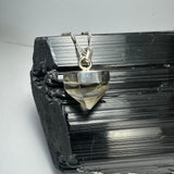 Quartz Pendant with silver clasp against a neutral background