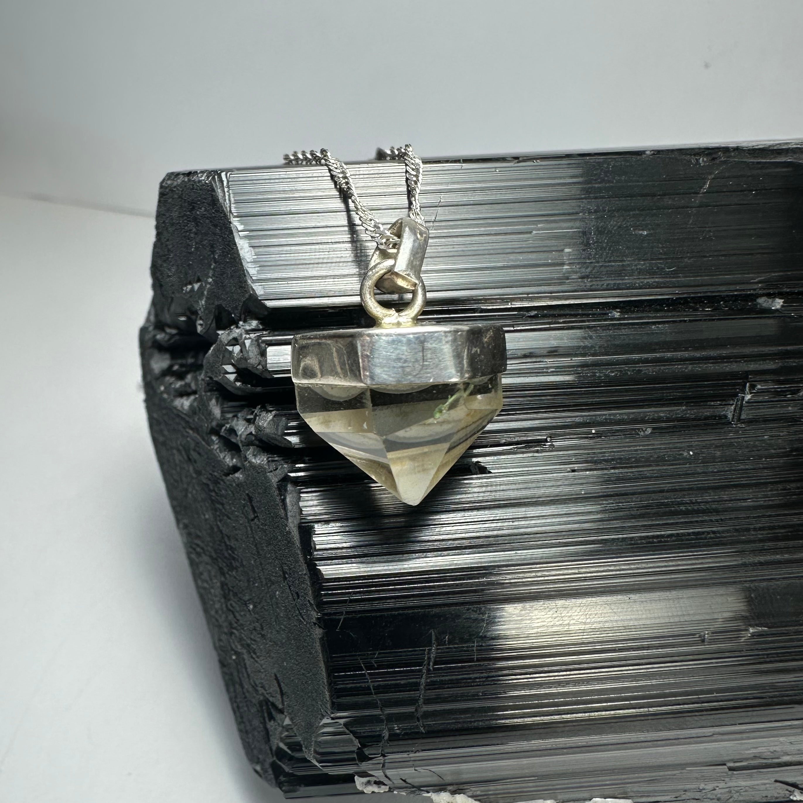 Quartz Pendant with silver clasp against a neutral background