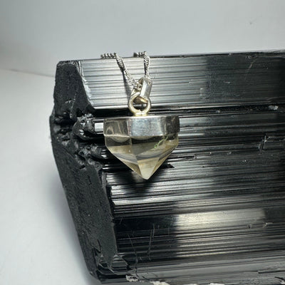 Quartz Pendant with silver clasp against a neutral background