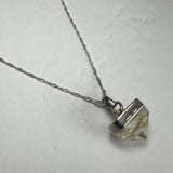 Clear quartz pendant with natural inclusions set in a silver-tone metal cap, hanging from a twisted silver chain on a white background.