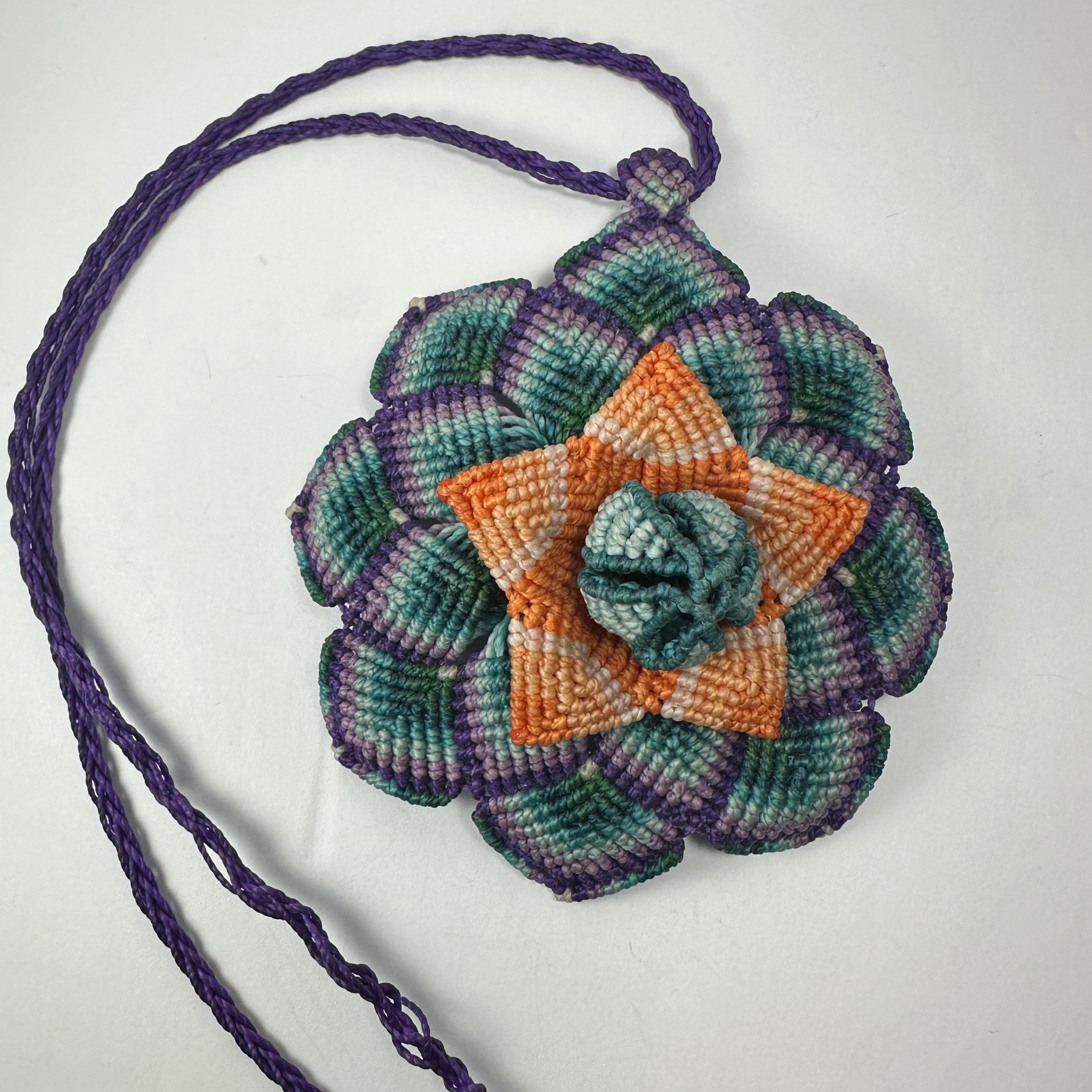 Hand-woven flower necklace featuring a macrame flower pendant and hematite bead end