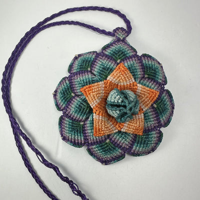 Hand-woven flower necklace featuring a macrame flower pendant and hematite bead end