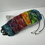 Handwoven bracelet with horizontal stripes transitioning through blue, purple, red, orange, yellow, green, and teal, separated by thin black lines with a black braided closure and white beads.
