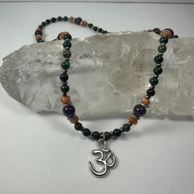 Handmade Bead Necklace with Silver 'Om' Pendant showing purple and orange beads with silver Om charm