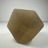 Translucent pale yellow fluorite dodecahedron with textured surface, displayed on white background under soft lighting.