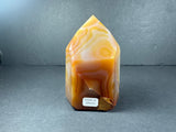 Polished banded carnelian tower from Brazil, showing orange and red color bands