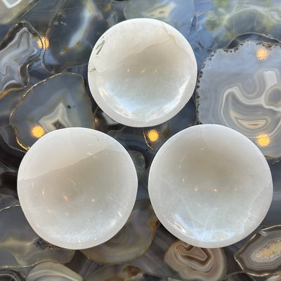 White selenite bowl with natural striations, softly glowing under natural light