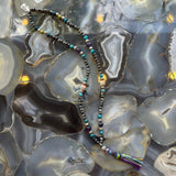 Close-up view of Larvikite Mala with mixed stone beads on a neutral surface