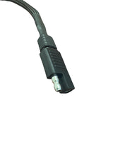 Close-up of a black dual Deutsch connector cable end with ribbed textured grip and silver metal pin, set against a white background.