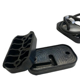 Black rubber mounting pad with grooves and holes shown separated from a metal dome light with attached black cables on a white background.