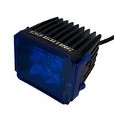 Black rectangular LED pod light with cooling fins and a transparent blue colored lens cover showing internal light reflector details