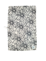 Drawing Daisies Kitchen Towel hanging with beige and black floral print visible
